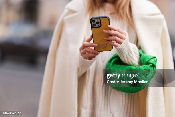 Sonia Lyson wearing a white nakd coat and pullover, a green bottega veneta mini Jodie bag on January 19, 2022 in Rome, Italy.