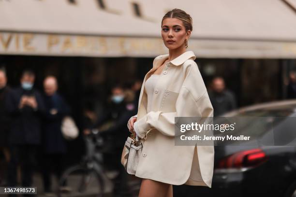 Amelie Zilber wears a gold large pendant earring from Fendi, a white shoulder-off short dress, a white latte jacket from Fendi, white matte First...