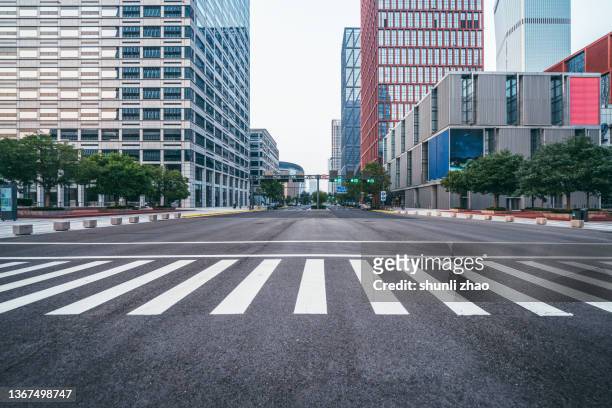 empty city street in financial district - road intersection stock-fotos und bilder