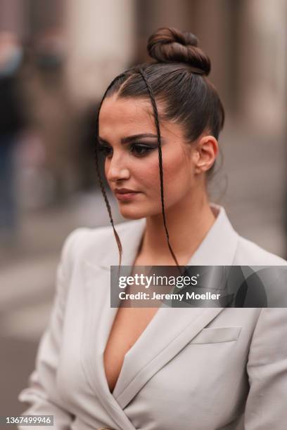 Gabrielle Caunesil wears a pale gray long cot, a gray with gold metallic monogram buckle belt from Fendi, a black shiny leather First handbag from...