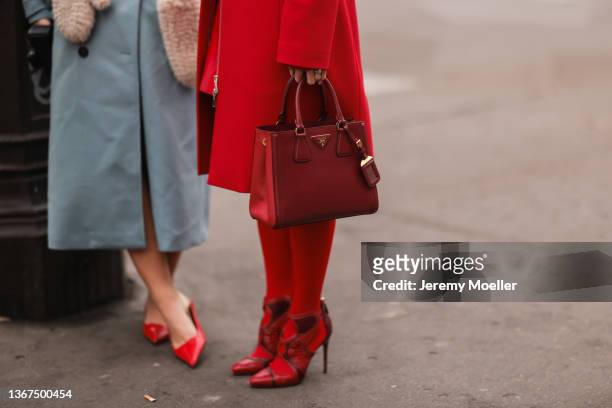 Mikialamode wears a red high neck polo shirt, a red shiny leather short skirt, a red long coat, red tights, a red grained leather Galleria handbag...