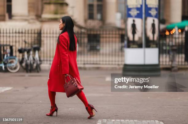 Mikialamode wears a red high neck polo shirt, a red shiny leather short skirt, a red long coat, red tights, a red grained leather Galleria handbag...