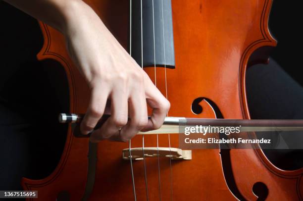 young girl playing cello, close-up. - strijkstok stockfoto's en -beelden