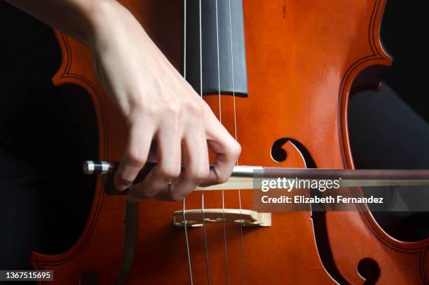 young girl playing cello, close-up. - musician imagens e fotografias de stock