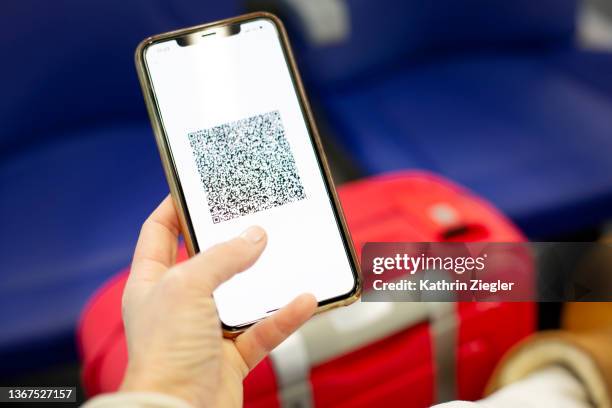 woman holding smart phone with digital green pass, close-up of hand - handpass stock-fotos und bilder