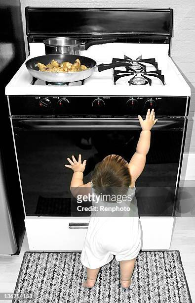 baby reaching for stove - child proof stock pictures, royalty-free photos & images