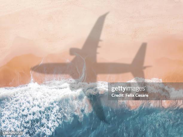 aerial view of an airplane shadow over a sandy beach. - avventure di viaggio foto e immagini stock