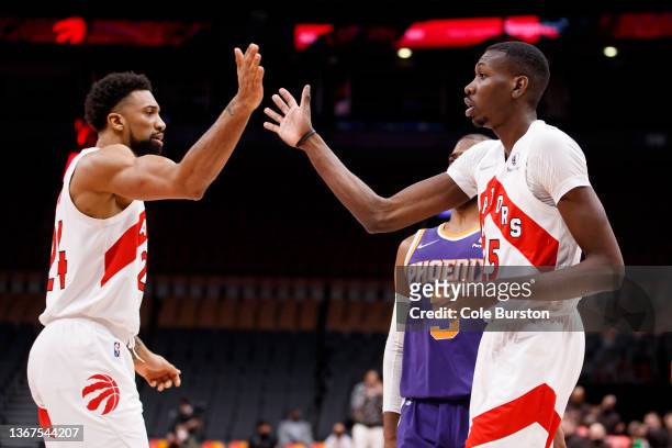 Khem Birch and Chris Boucher of the Toronto Raptors high five during the second half of their NBA game against the Phoenix Suns at Scotiabank Arena...