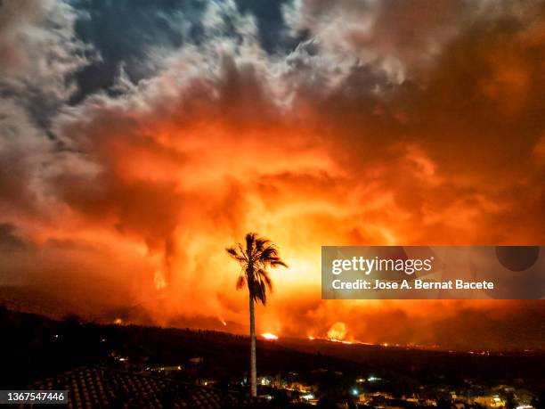 crater of an erupting volcano spewing pyroclasts in the night. view of the cumbre vieja volcano with a column of smoke and lava coming out of the main cone. - destruction city stock pictures, royalty-free photos & images