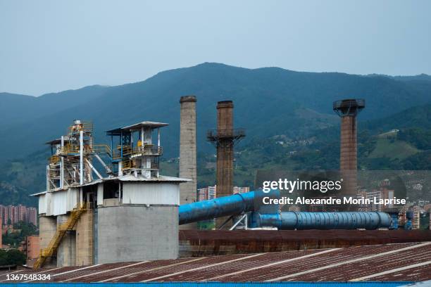 old industrial plant rooftop against blue mountains at dusk - colombia mountains stock pictures, royalty-free photos & images