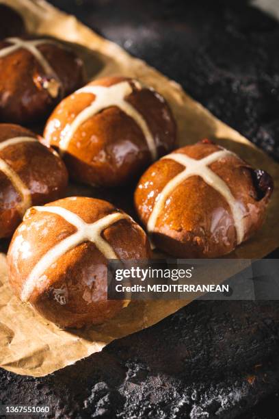 homemade easter hot cross buns just fresh baked over baking paper on black tray - hot cross bun stock pictures, royalty-free photos & images