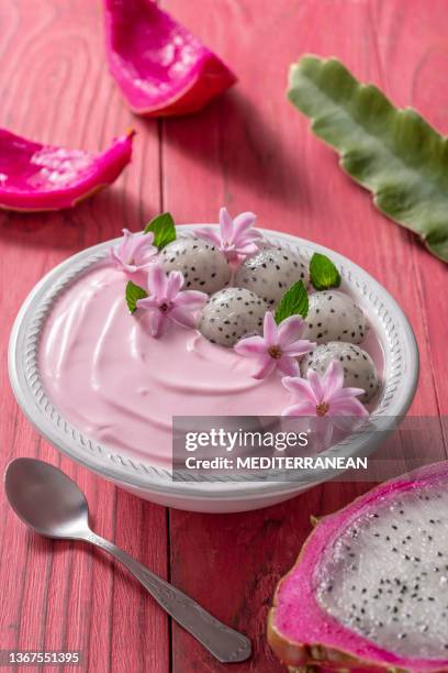 pitahaya and strawberry yogurt breakfast bowl, mint leaves, pink flowers decoration on pink wood table - texture mousse stock pictures, royalty-free photos & images