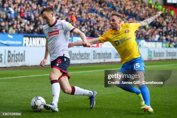 George Johnston of Bolton Wanderers battles for possession with Carl Winchester of Sunderland during the Sky Bet League One match between Bolton...