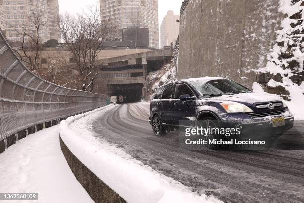 An S.U.V. Slowly drives up a steep road covered in snow and slush on January 29, 2022 in West New York, New Jersey. Parts of New Jersey have already...