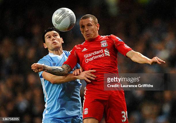 Craig Bellamy of Liverpool goes up for a header with Gareth Barry of Manchester City during the Carling Cup Semi Final First Leg match between...