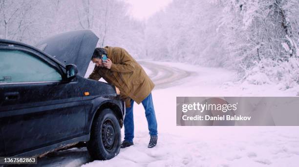 uomo con problemi di auto sulla strada invernale, telefonata per chiedere aiuto. - vehicle breakdown foto e immagini stock