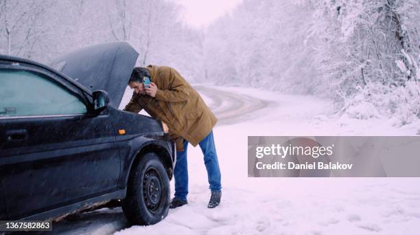 man with car issues on winter road, phone calling for help. - vehicle breakdown stock pictures, royalty-free photos & images