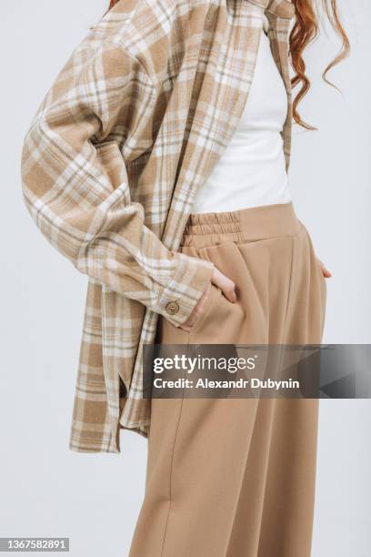 close-up of pants and shirt with hands in pockets on a white background. - pantalon beige photos et images de collection