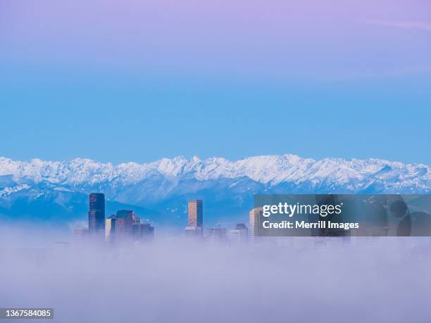 seattle skyscrapers poking through low clouds at dawn, viewed from bellevue - olympic peninsula photos et images de collection