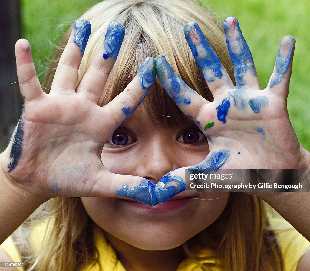Small girl showing finger painting