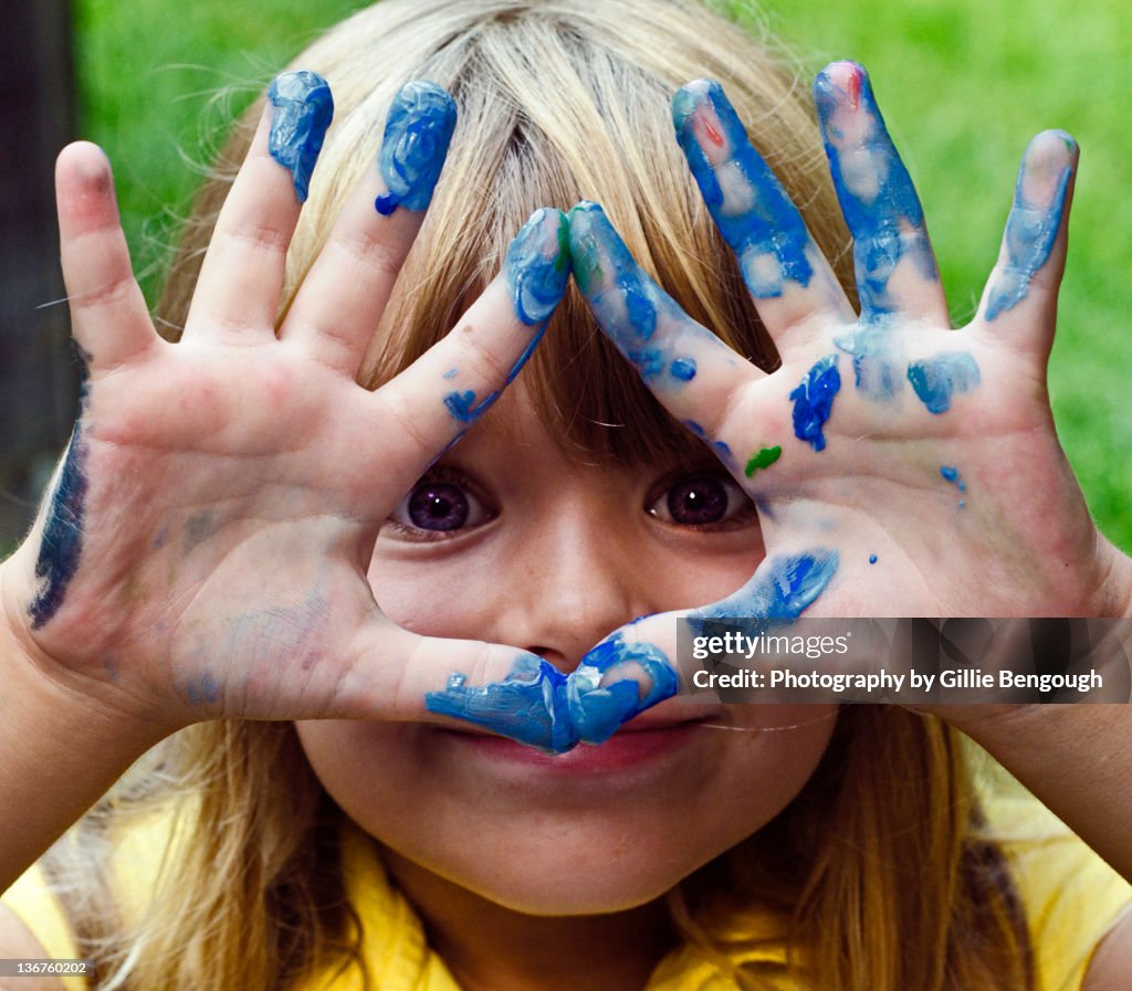 Small girl showing finger painting