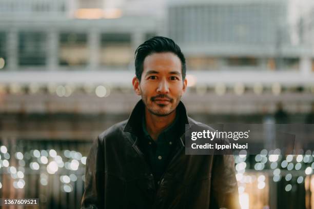 man looking at camera at dusk in city - guy stubble foto e immagini stock