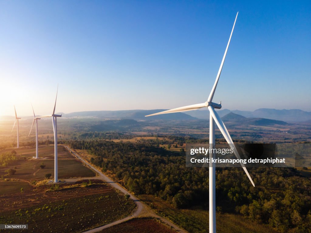 Panoramic view of wind farm or wind park, with high wind turbines for generation electricity with copy space. Green energy concept.