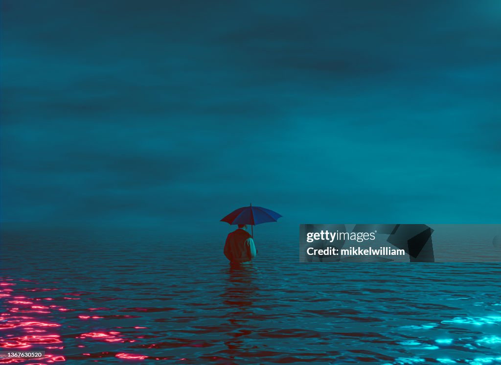 Hombre con sombrillas en el mar por la noche