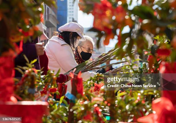 Customers shop for flowers at the Chinese New Year Flower Market Fair in Chinatown on January 29, 2022 in San Francisco, California.