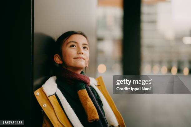 young girl pondering in city in winter at dusk - endast en flicka bildbanksfoton och bilder