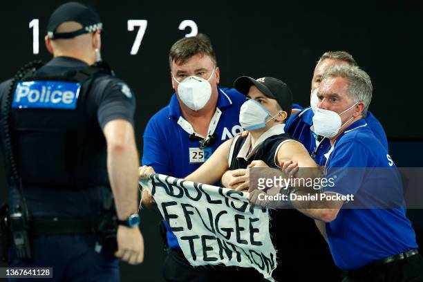 Protester is apprehended during the Men's Singles Final match between Rafael Nadal of Spain and Daniil Medvedev of Russia during day 14 of the 2022...