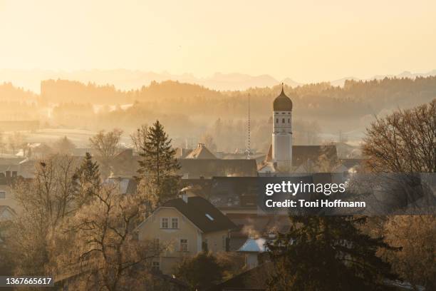 morning light hitting the village andechs on a foggy winter day - starnberg stock-fotos und bilder