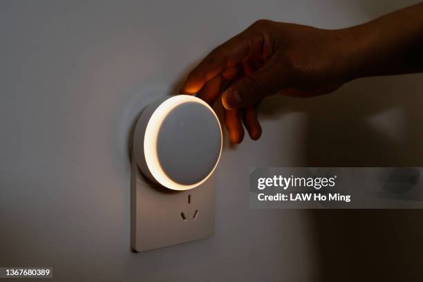 an asian male is installing an automatic sensor light for smart homes - take control imagens e fotografias de stock