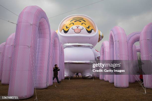 The boy pass through an Inflatable of spacesuit tiger in Expo garden on January 30, 2022 in Wuhan, Hubei, China. China will be marking the Spring...