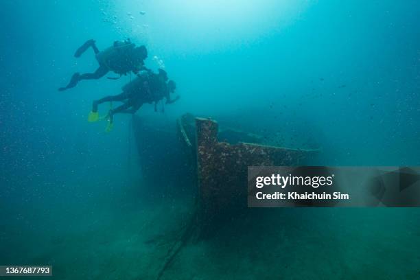 scuba divers and shipwreck underwater - épave de bateau photos et images de collection