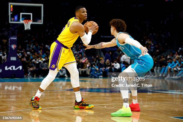 Russell Westbrook of the Los Angeles Lakers looks over the court as he is guarded by LaMelo Ball of the Charlotte Hornets during the first half of...