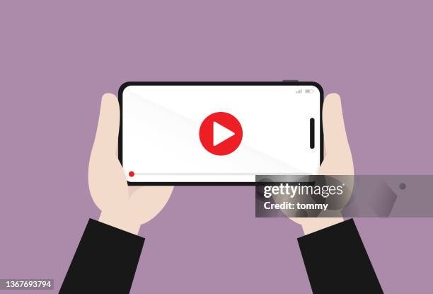ilustraciones, imágenes clip art, dibujos animados e iconos de stock de sostiene con la mano un teléfono móvil para reproducir video - mirar un objeto