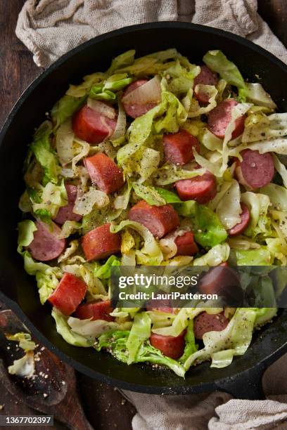 fried cabbage with onions and kielbasa - kielbasa stock pictures, royalty-free photos & images