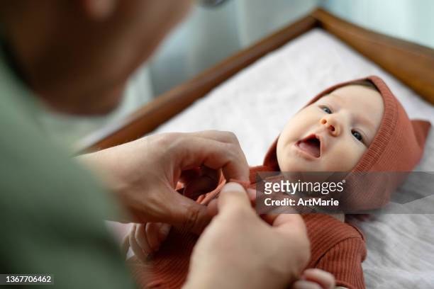 vater setzt hut auf sein süßes mädchen - babyausrüstung stock-fotos und bilder