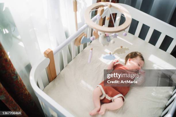 süßes kleines mädchen in ihrer krippe - babybett stock-fotos und bilder