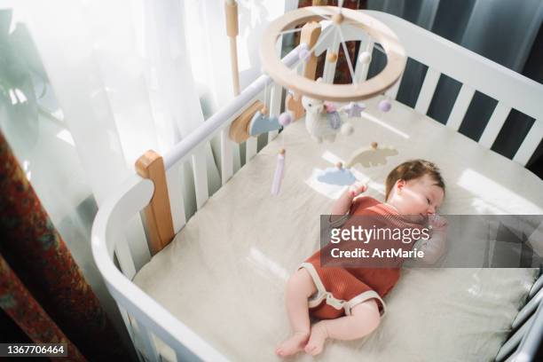 彼女のベビーベッドでかわいい女の赤ちゃん - sleeping ストックフォトと画像