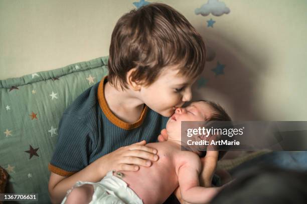 little boy kissing his newborn sister - brother toddler sister stockfoto's en -beelden