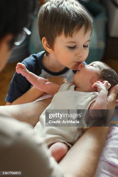 little boy kissing his newborn sister - latest bro pics stockfoto's en -beelden