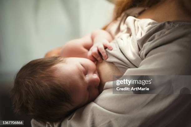 mother breastfeeding her newborn baby girl - tranquil scene stock pictures, royalty-free photos & images