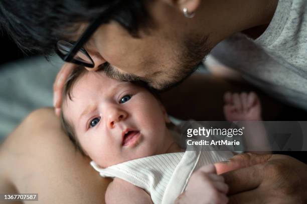 男は彼の赤ちゃんの女の子にキス - couple portrait soft ストックフォトと画像