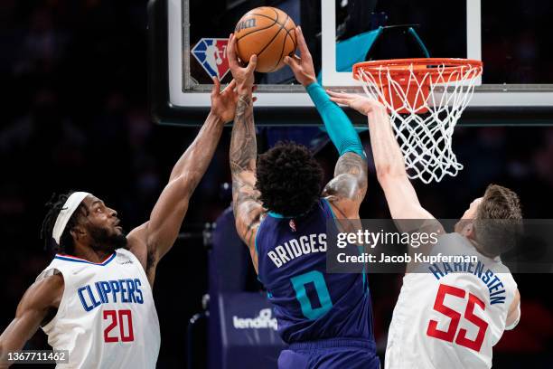 Miles Bridges of the Charlotte Hornets drives to the basket while guarded by Justise Winslow and Isaiah Hartenstein of the Los Angeles Clippers in...