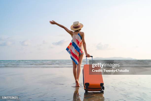 happy asian woman with sunhat enjoy travel on the beach in summer - maleta fotografías e imágenes de stock