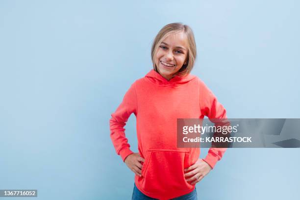 portrait of a beautiful blonde teenage girl with happy eyes on blue background. - 10 11 jaar stockfoto's en -beelden