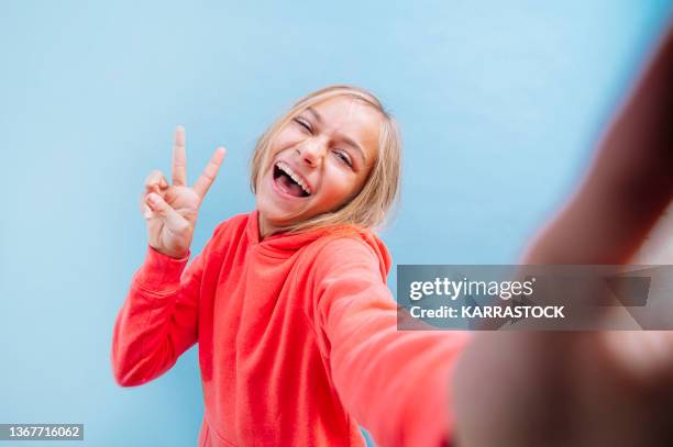 portrait of a beautiful blonde teenage girl with eyes taking a selfie. - autofoto fotografías e imágenes de stock