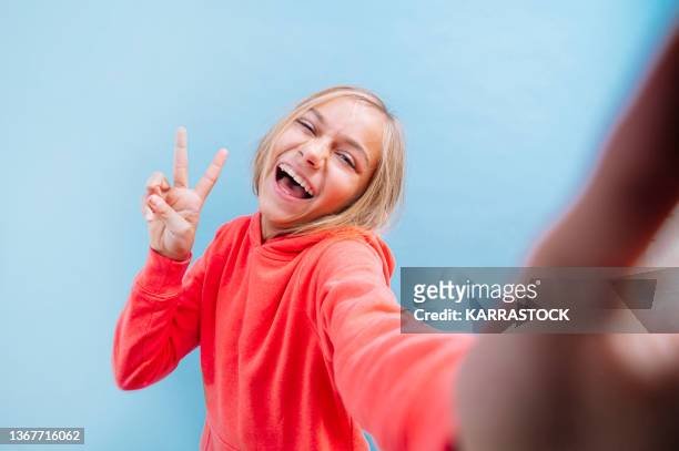 portrait of a beautiful blonde teenage girl with eyes taking a selfie. - adolescents selfie ストックフォトと画像